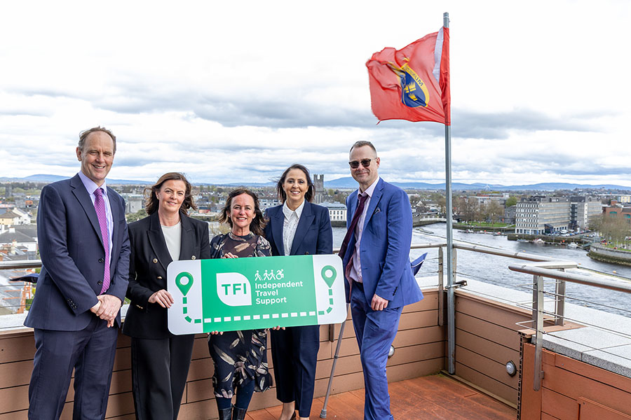 Independent Travel Support banner 900x600 pix launch of service in Limerick - with Munster flag and NTA and BusEireann staff