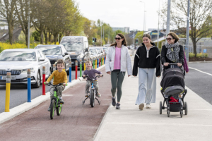 children in cyclelane - pencil posts- 3 women walking one with baby buggy Limerick