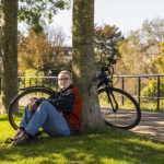 cyclist taking a rest by a tree in a Galway park