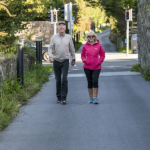 woman and man walking on a rural walkway path in Galway