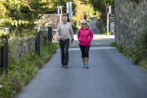 woman and man walking on a rural walkway path in Galway